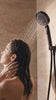 Femme sous la douche en travertin avec le pommeau de douche noir mat Maison Bréa, format mobile